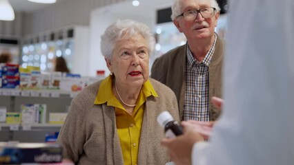 Senior couple buying medications, pharmacist examining how to dose. - Powered by Adobe