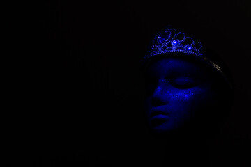 Bright crown  on black head on black background