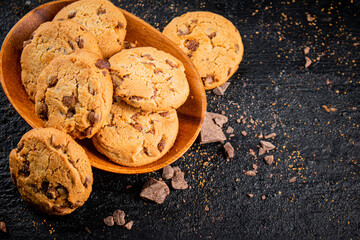 Wooden plate with cookies and pieces of milk chocolate. 