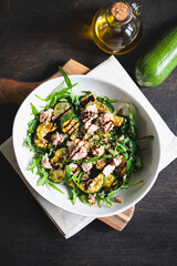 fresh salad with arugula, baked zucchini and tuna. the concept of healthy and nutritious food