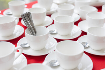 set of white tea cups on red tablecloth