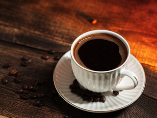 A cup of espresso coffee on a dark wooden table, roasted coffee beans. top view