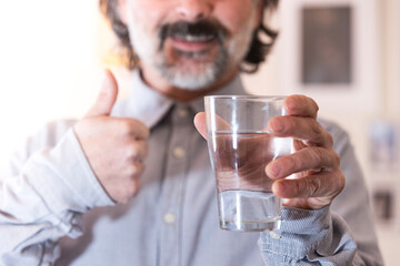 happy man gives recommendations for healthy lifestyle enjoying crystal clean water at home