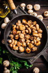 Fragrant homemade fried mushrooms in a frying pan on a cutting board. 