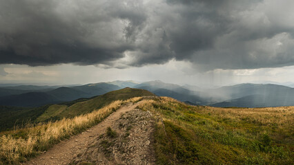 Panorama w Bieszczadach z Połoniny Caryńskiej. Ciemne burzowe chmury , zwiastun oberwania chmury i nawałnicy