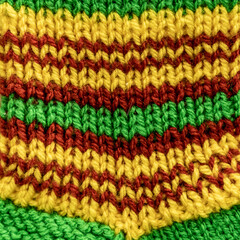 Fototapeta na wymiar The texture of a knitted fabric with a pigtail pattern