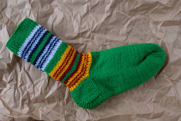 Hand knitted woolen striped socks on kraft paper background