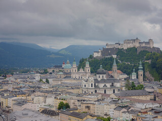 Fototapeta premium Salzburg Austria inner city with churches. Beautiful view of Salzburg skyline with Festung Hohensalzburg in cloudy summer, Salzburg, Salzburger Land, Austria. Hohensalzburg fortress and Salzburger Dom