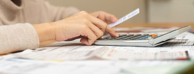 Financial owe asian young woman, girl suffer, stressed and confused, hand use calculator calculate expense from invoice or bill, have no money to pay, mortgage or loan. Debt, bankruptcy or bankruptcy.