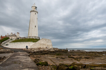 Fototapeta na wymiar Dark cloudy skies over St Mary's LIghthouse at Whitley Bay in Tyne and Wear, UK