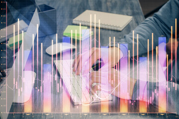 Stock graph with businessman typing on computer in office on background. Concept of analysis. Double exposure.