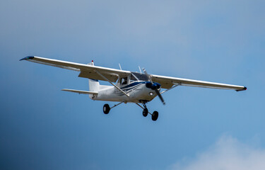 Fototapeta na wymiar Single prop engine small airplane flying in blue skies