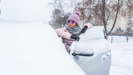 Fototapeta na wymiar Woman in sunglasses leaning onto open front door of a car under snow . High quality photo