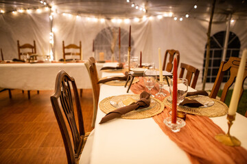 Amazing Out of the box wedding venue tent with dinner equipment on tables and warm fairy string lights