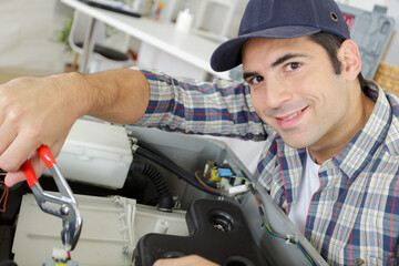 male technician repairing a digital photocopier machine