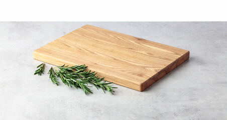 Cutting board and rosemary on a grey stone table.
