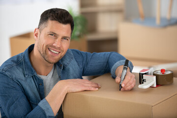 Fototapeta premium happy man is writing on a box