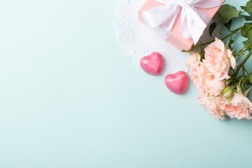A banner layout with a gift, roses and a knitted heart on a light blue background.