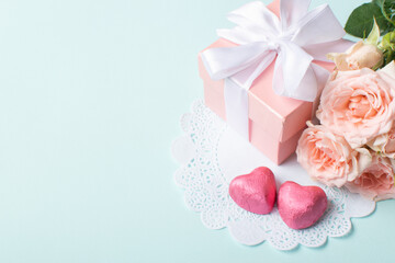 A banner layout with a gift, roses and a knitted heart on a light blue background.