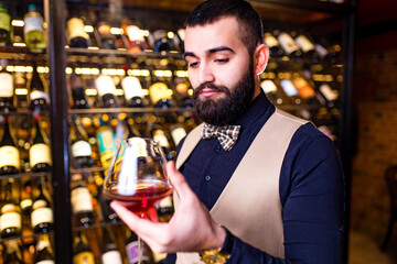 arabian man sommelier appreciating drink in lux hotel