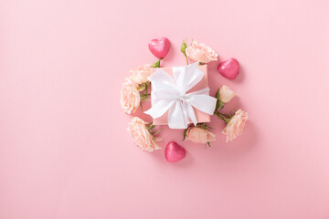 Valentine's Day background. A banner layout with a gift, roses and hearts on a light pink background with a space for text.