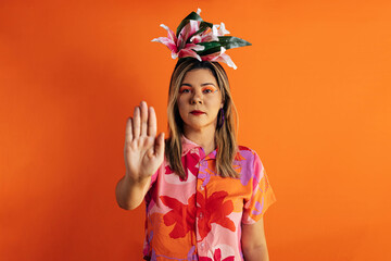 Young beautiful woman wearing carnival costume over color background making stop singing with palm of hand