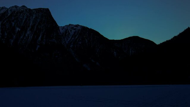 Sunrise over the frozen Lake Piburger. Oetztal, Austria.