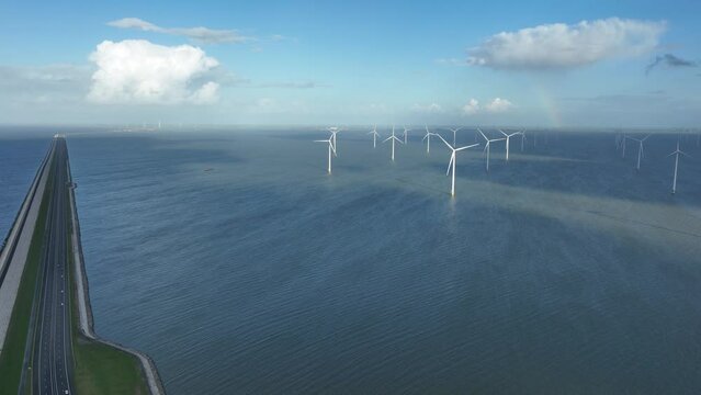 Aerial drone video of the Afsluitdijk in the Netherlands featuring wind turbines in the background, showcasing the country's investment in renewable energy and coastal protection.