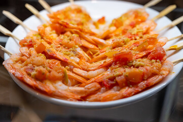 Typical snack of Basque Country, pinchos or pinxtos skewers with small pieces different fish and sea food, served in bar in San-Sebastian or Bilbao, Spain