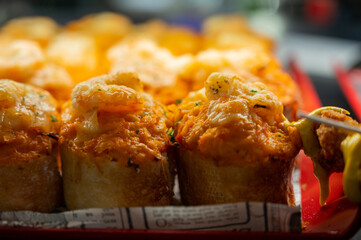 Typical snack of Basque Country, pinchos or pinxtos skewers with small pieces of bread, sea food, eggs, cheese, jamon served in bar in San-Sebastian or Bilbao, Spain