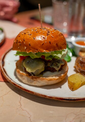 Organic vegetarian burger with plant based falafel balls, vegan cheese, green lettuce and baked potatoes