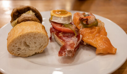 Board with typical snacks of Basque Country, pinchos or pinxtos, skewers or small piece of bread with toppings, served in bar in San-Sebastian or Bilbao, Spain