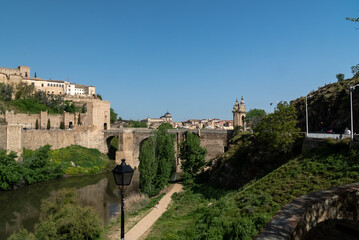 Fototapeta na wymiar Toledo, España. April 29, 2022:Alcantara Roman Bridge with landscape and blue sky.
