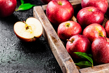 Ripe red apples on a wooden tray. 