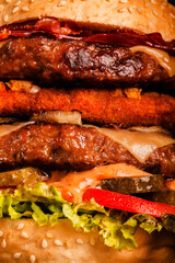 Double burger with bacon grilled yellow cheese onions tomatoes cucumber and lettuce. Abstract fast food background.