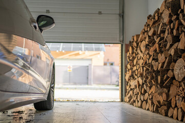 Low angle view of garage with a parked car full of firewood for the winter