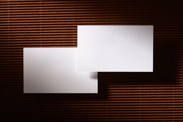Flat lay of two business card on brown surface