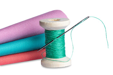 sewing thread on a bobbin and a sewing needle on a white background