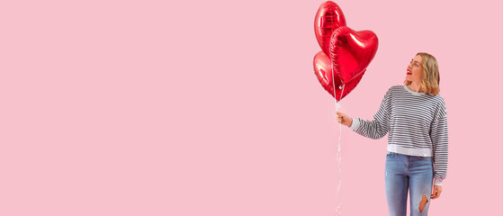 Beautiful young woman with heart-shaped balloons on pink background with space for text....