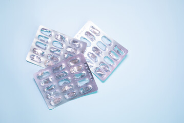 Used drugs, used capsules, Used antibiotic packaging on blue background. Close-up of empty pill package. 
