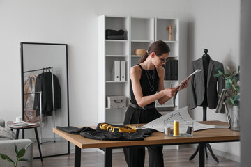 Female dressmaker working at table in modern atelier