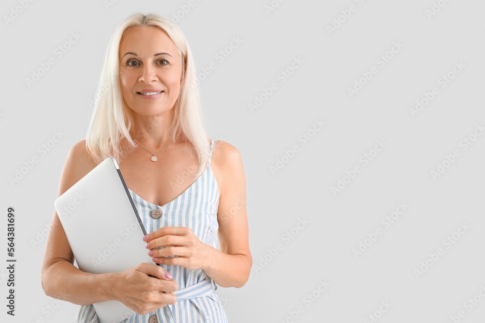 Sticker Mature blonde woman with laptop on light background