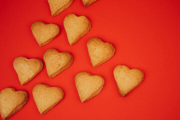 Shortbread cookies in the form of hearts on a red background. Background, Valentine's Day. Flat lay