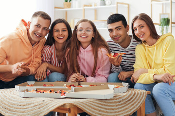 Group of friends eating pizza in living room