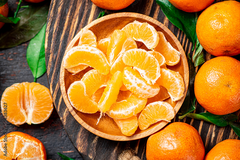 Wall mural Juicy tangerines with leaves on a wooden tray. 