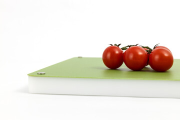 Vegetables on green professional chopper - red cherry tomatoes