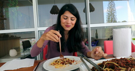 Happy woman eating lunch turning spaghetti