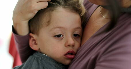 Exhausted child on mother lap parent love and care of sleepy small boy