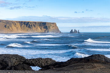 Dyrhólaey (Dyrholaey, Door Hill Island, Cape Portland), small promontory located on south coast of Iceland, near Vik. Reynisfjara and Reynisdrangar as seen from Dyrhólaey. Stone arch.