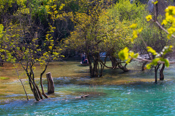 Small boat rowing just under Kravica waterfalls in southern Bosnia and Herzegovina